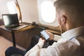 Young attractive and successful businessman is resting and listening to music works while sitting in the chair of his Royalty Free Stock Photo