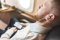 Young attractive and successful businessman is resting and listening to music works while sitting in the chair of his Royalty Free Stock Photo