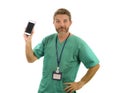 Young attractive and successful medicine doctor or nurse man posing confident  in green medical uniform holding mobile phone Royalty Free Stock Photo