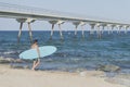 Young attractive surfer holding his surfboard at the beach Royalty Free Stock Photo