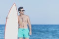 Young attractive surfer holding his surfboard at the beach Royalty Free Stock Photo