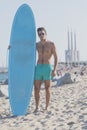 Young attractive surfer holding his surfboard at the beach Royalty Free Stock Photo