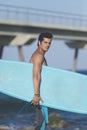 Young attractive surfer holding his surfboard at the beach Royalty Free Stock Photo