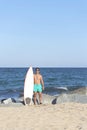 Young attractive surfer holding his surfboard at the beach Royalty Free Stock Photo