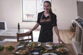 Young attractive swedish food blogger posing in front of a table full of food dishes. Young girl sitting in front of a wooden Royalty Free Stock Photo