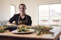 Young attractive swedish food blogger posing in front of a table full of food dishes. Young girl sitting in front of a wooden Royalty Free Stock Photo