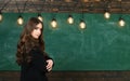 Young attractive teacher pointing at chalkboard. Education first. Student life. Back to school and happy time. Royalty Free Stock Photo