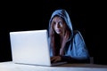 Young attractive teen woman wearing hood on hacking laptop computer cybercrime cyber crime concept Royalty Free Stock Photo