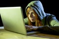 Young attractive teen woman wearing hood on hacking laptop computer cybercrime cyber crime concept Royalty Free Stock Photo