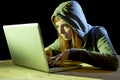 Young attractive teen woman wearing hood on hacking laptop computer cybercrime cyber crime concept Royalty Free Stock Photo