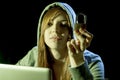 Young attractive teen woman wearing hood on hacking laptop computer cybercrime cyber crime concept Royalty Free Stock Photo