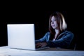 Young attractive teen woman wearing hood on hacking laptop computer cybercrime cyber crime concept