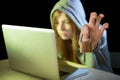 Young attractive teen woman wearing hoodie hacking laptop cybercrime cyber crime concept