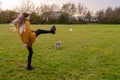 Young attractive teenager girl playing with Yorkshire terrier game of catch the ball on a grass in a park. The model with long Royalty Free Stock Photo