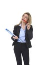 Young attractive and thoughtful business woman with blue folder and pen thinking about project Royalty Free Stock Photo