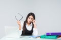 Young attractive tired, overworked and exhausted female office worker in grey suit, isolated on white background