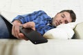 Young attractive tired and overworked falling asleep at home couch with mobile phone and digital tablet pad Royalty Free Stock Photo