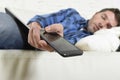 Young attractive tired and overworked falling asleep at home couch with mobile phone and digital tablet pad Royalty Free Stock Photo