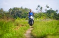 Young attractive tourist afro American black woman riding motorbike happy in beautiful Asia countryside along green rice fields