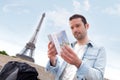 Young attractive tourist reading a guide of Paris