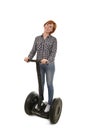 Young attractive tourist woman with red hair wearing jeans smiling happy riding electrical segway