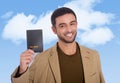 Young attractive traveler man holding passport smiling happy and confident