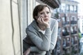 Young attractive unhappy depressed lonely woman looking sad on the balcony at home. urban view Royalty Free Stock Photo
