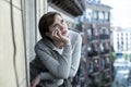 Young attractive unhappy depressed lonely woman looking worried on the balcony at home. urban view Royalty Free Stock Photo