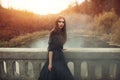 Young attractive Witch walking on the bridge in heavy black smoke. Royalty Free Stock Photo