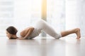 Young attractive woman in Ashtanga Namaskara pose against floor