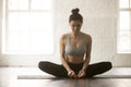 Young attractive woman in baddha konasana pose, white loft studi Royalty Free Stock Photo