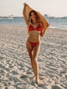 Young attractive woman in bikini with big hat posing at sandy beach Royalty Free Stock Photo