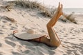 Young attractive woman in bikini with big straw hat posing at sandy beach