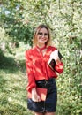 Young attractive woman with blond short hair, wearing red shirt and black skirt, holding books in her hands. Three-quarter Royalty Free Stock Photo