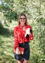 Young attractive woman with blond short hair, wearing red shirt and black skirt, holding books in her hands. Three-quarter Royalty Free Stock Photo