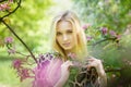 Young attractive woman in blooming spring trees