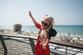 Young attractive woman in bright red dress dances on the city promenade Royalty Free Stock Photo