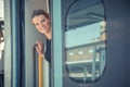 Young attractive woman bussinessman says goodbye to a boarder on train train. He enters the international train with his luggage Royalty Free Stock Photo