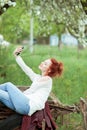 Young attractive woman is busy with her mobile phone doing selfies, writing, reading Royalty Free Stock Photo