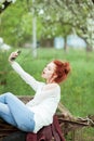 Young attractive woman is busy with her mobile phone doing selfies, writing, reading Royalty Free Stock Photo