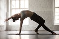 Young attractive woman in Camatkarasana pose, white loft studio