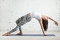 Young attractive woman in Camatkarasana pose, white studio backg