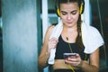 Young attractive woman caucasian sitting and listening to music by earphones connect to smart phone.