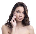 Young attractive woman cleanses the face with a cotton pad. Skincare concept.