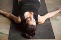 Young attractive woman in Corpse pose, studio floor background Royalty Free Stock Photo