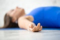 Young attractive woman in Corpse pose, white studio background