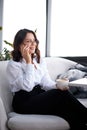 Young attractive woman with cute smile talking on mobile phone while sitting alone in coffee shop during break time Royalty Free Stock Photo