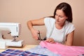 Young attractive woman cutting fabric