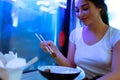 Young attractive woman eating asian food with chopsticks at cafe or restaurant. Royalty Free Stock Photo
