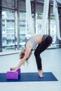 Young attractive woman elongating muscles before training